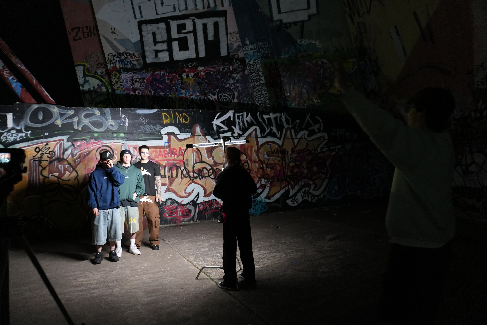 Campaña Stay Under: el grupo en un descampado con muro de graffiti, de noche